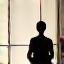 Persona meditante in una posa di loto con un'atmosfera serena e luci soffuse